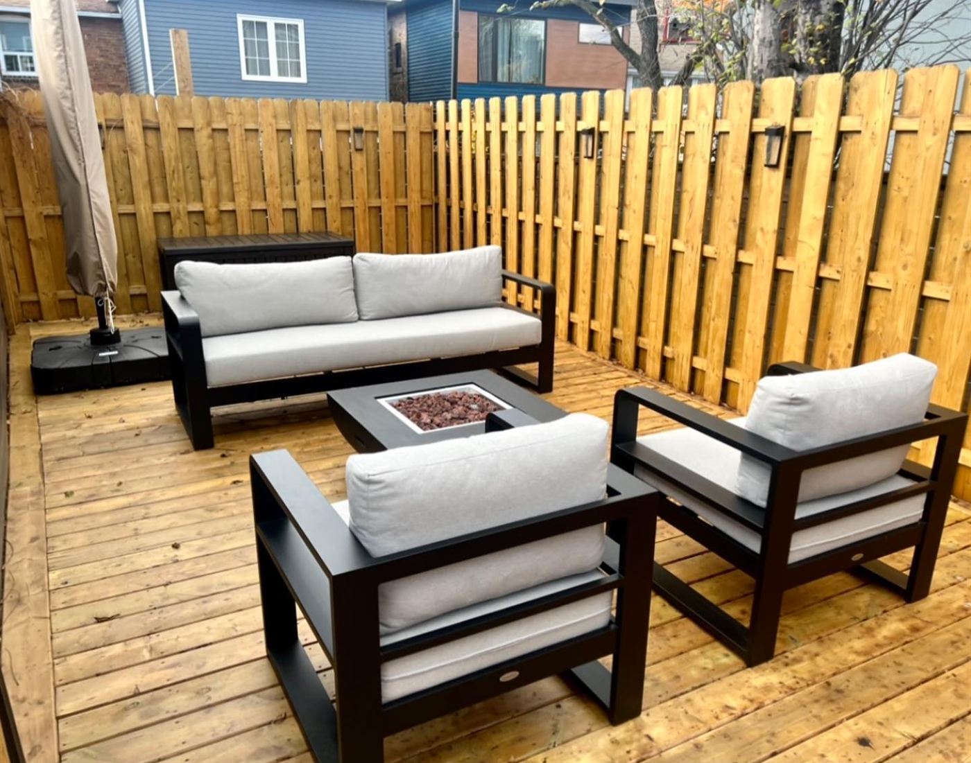 Deck lounge area with outdoor sofa, chairs and a gas fire table